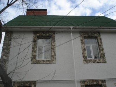 Окна на этом фото декорированы искусственным камнем