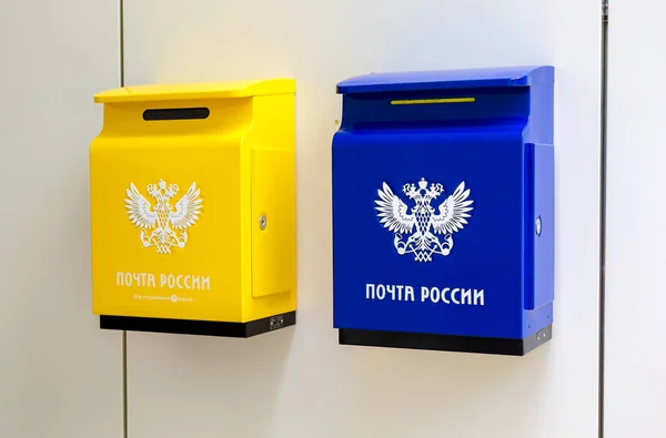 Желтый и синий почтовые ящики на стене рядом с почтовое отделение — стоковое фото