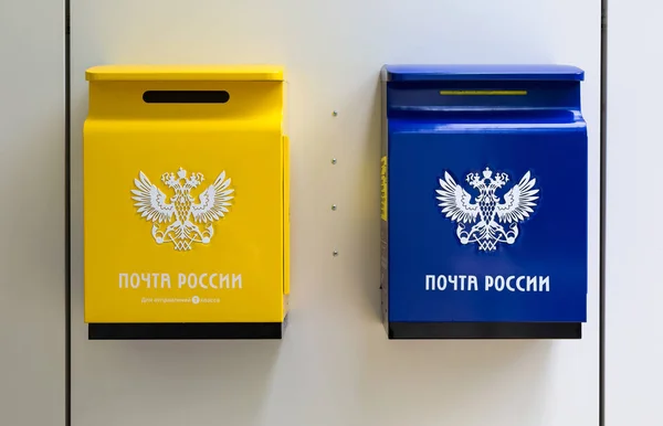 Желтый и синий почтовые ящики на стене рядом с почтовое отделение — стоковое фото