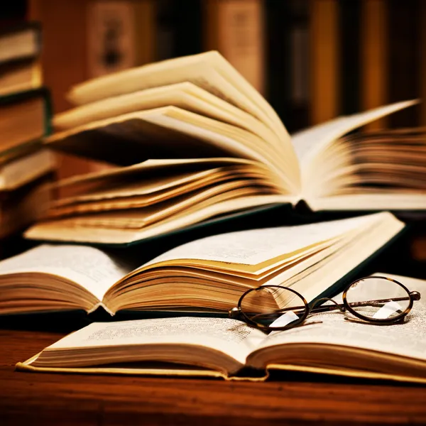 Открытая книга, лежащая на книжной полке — стоковое фото